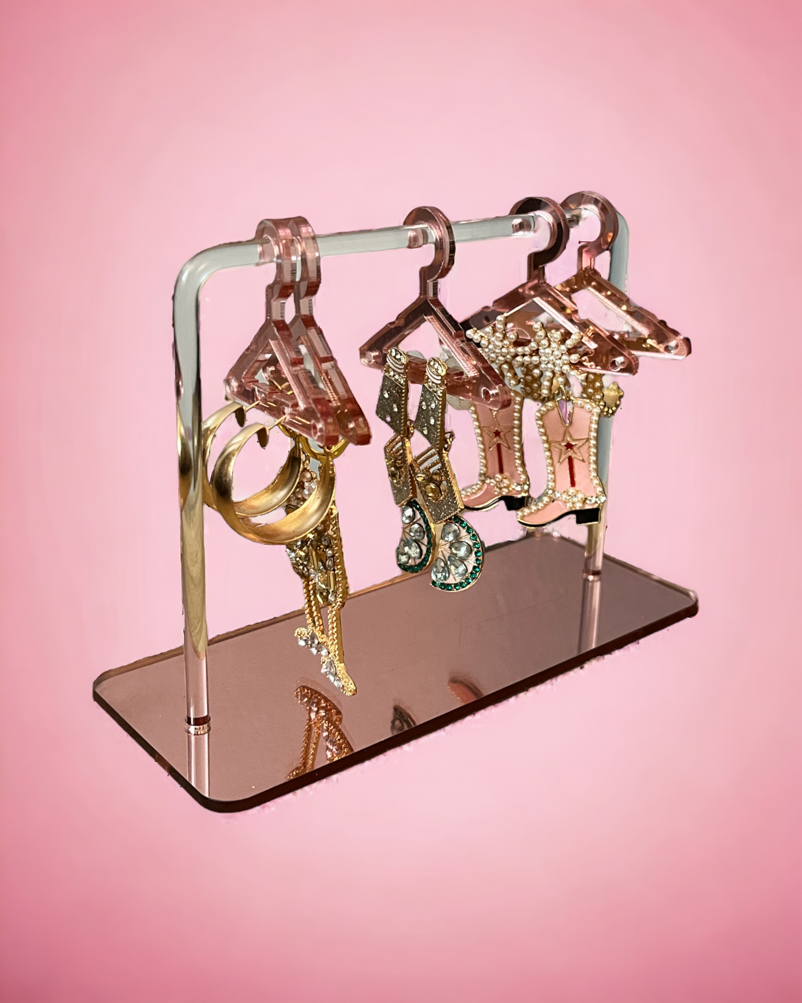 image of an earring holder titled `'coat of earrings" that mimics a coat rick but miniature with tiny hangers for the earrings