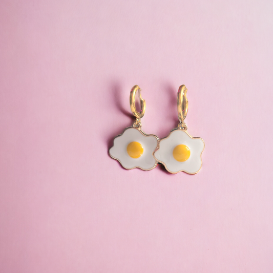 image of sunny side up egg earrings by gumptious on pink background 